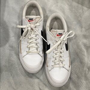 Nike White Low-Top Sneakers with Black Swoosh and Red Tongue Logo